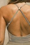 Close up detail back view of model posing in the fitted dune washed rib Cross Back Cami with a scoop neckline and thin adjustable straps that criss cross in the back