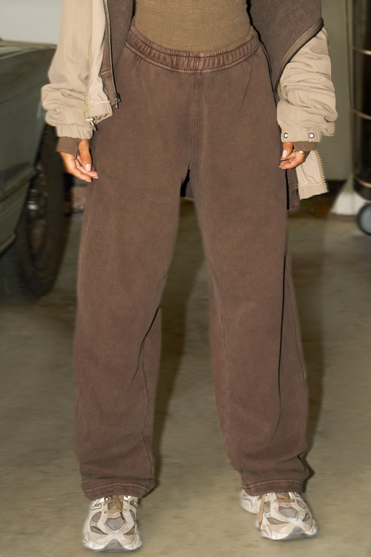 Front view of model from the waist down posing in the relaxed fit cedar french terry Oversized Straight Leg Jogger with an elastic waistband, hidden drawstring, pocket details. and adjustable cinching at the ankle cuffs