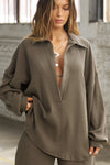 Front view of model posing in the oversized army luxe knit Deep V Pullover with a plunging collared neckline and dropped shoulders
