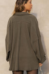 Back view of model posing in the oversized army luxe knit Deep V Pullover with a plunging collared neckline, dropped shoulders and back panel details