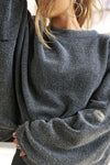 Close up detail front view of model posing in the relaxed fit storm sherpa Drop Shoulder Pullover sweatshirt with an exaggerated crew neckline, dropped shoulders and a custom Joah Brown Logo Patch on the left sleeve 