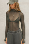 Front view of model posing in the fitted and sheer graphite mesh Exposed Seams Long Sleeve top with a mock neckline and exposed seam details