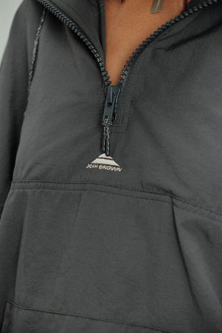 Close up detail front view of model posing in the relaxed fit jet nylon 3/4 Zip Windbreaker jacket with a structured collar and 3/4 zip neckline