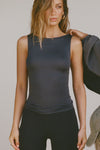 Front view of model posing in the fitted, lightweight black modal Boatneck Tank top with a boat neckline