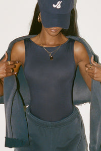 Front view of model posing in the fitted, lightweight navy modal Boatneck Tank top with a boat neckline