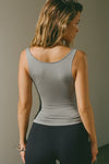 Back view of model posing in the fitted, lightweight shadow modal Boatneck Tank top with boat neckline and scoop back