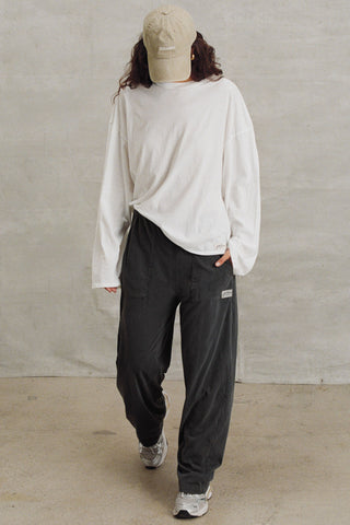 Full body front view of model posing in the relaxed fit, lightweight optic white classic cotton Boxy Crew Long Sleeve top with a crew neckline, dropped shoulders and oversized silhouette
