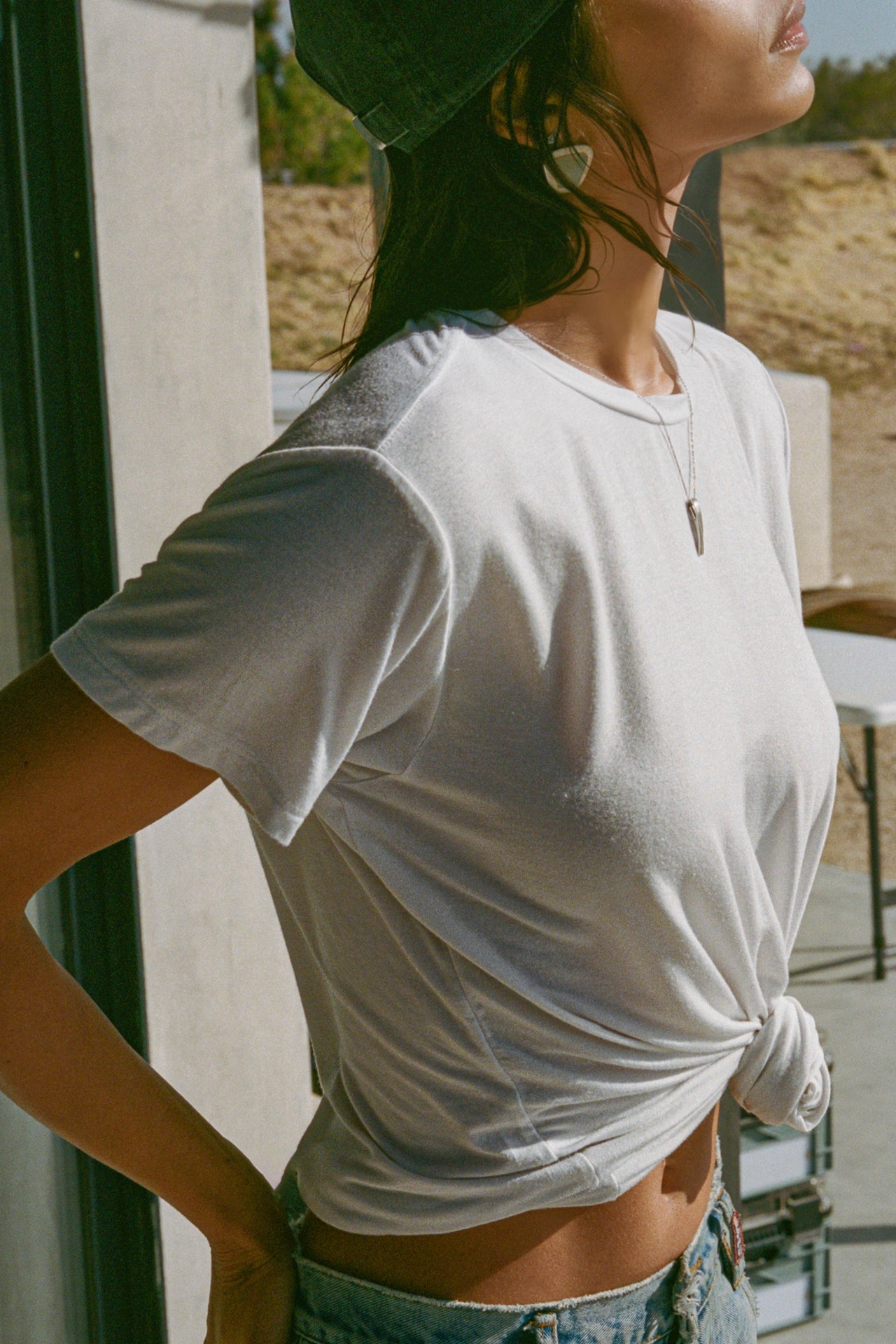 Side view of model posing in the relaxed fit white modal Boyfriend Tee with a crew neckline