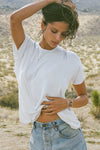 Front view of model posing outside in the desert in the relaxed fit white modal Boyfriend Tee with a crew neckline