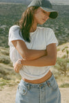 Front view of model posing outside in the desert in the relaxed fit white modal Boyfriend Tee with a crew neckline