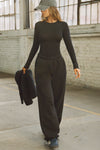 Full body front view of model posing in the fitted and lightweight black modal Classic Crew Long Sleeve top with a crew neckline