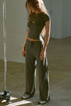 Full body front view of model posing in the relaxed fit spruce modal Relaxed Straight Leg Pant with a wide leg, elastic waistband, adjustable drawstring tie and subtle pleating at the sides.