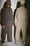 Two models posing in a jet nylon and desert sage nylon Classic Windbreaker Jacket and Barrel Pant sets