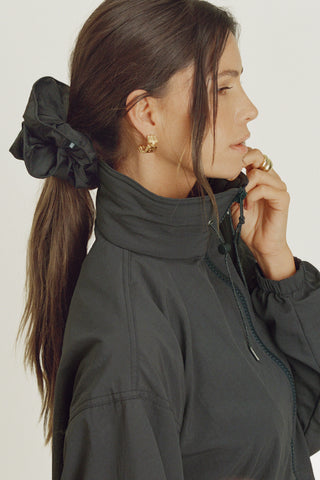 Side view of model posing in the oversized jet Nylon Scrunchie with a voluminous silhouette.