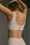 Back view of model posing in the stretchy and sculpting sueded yuma contour bra with a scoop back and curved hem