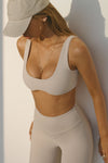 Sidt view of model posing in the stretchy and sculpting sueded yuma contour bra with a deep scoop neckline and curved hem
