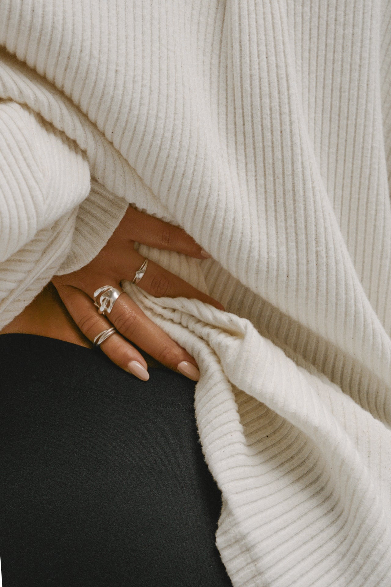 Close up detail  view of model posing in the oversized natural luxe knit Deep V Pullover with a plunging collared neckline and dropped shoulders