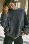 Front view of model posing in the relaxed fit storm sherpa Drop Shoulder Pullover sweatshirt with an exaggerated crew neckline, dropped shoulders and a custom Joah Brown Logo Patch on the left sleeve 