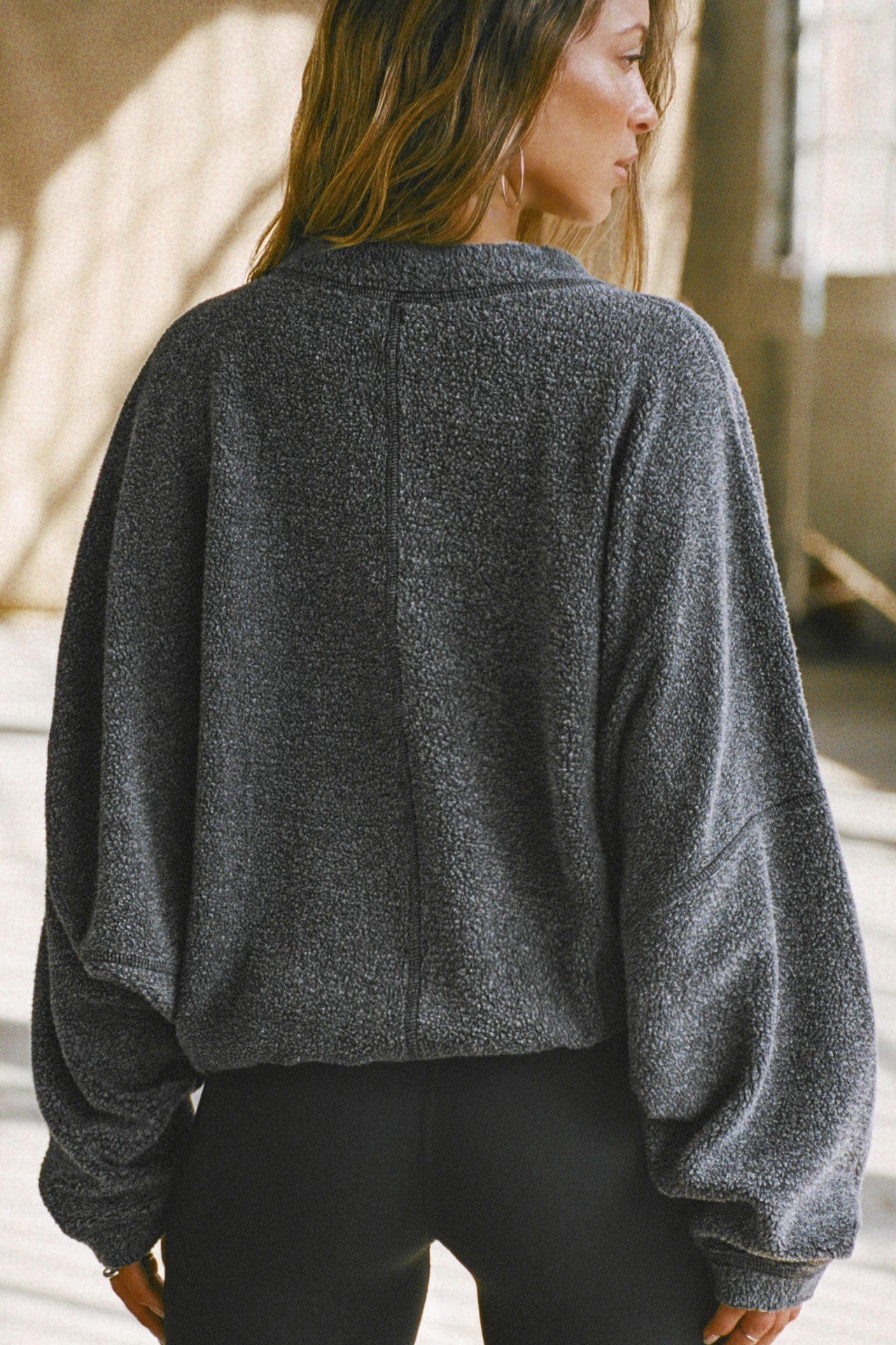 Back view of model posing in the relaxed fit storm sherpa Drop Shoulder Pullover sweatshirt with an exaggerated crew neckline, dropped shoulders and a custom Joah Brown Logo Patch on the left sleeve 