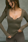 Front view of model posing in the fitted woodland rib Henley Long Sleeve with a notch in the scoop neckline