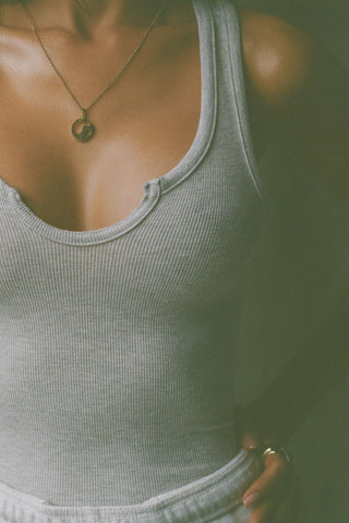 Close up detail front view of model posing in the fitted, full length pearl grey flexrib Henley Tank with a notched henley neckline