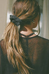 Back view of model wearing the soft and stretchy ink luxe knit Knit Scrunchie wrapped around her pony tail