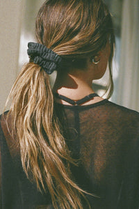 Back view of model wearing the soft and stretchy ink luxe knit Knit Scrunchie wrapped around her pony tail