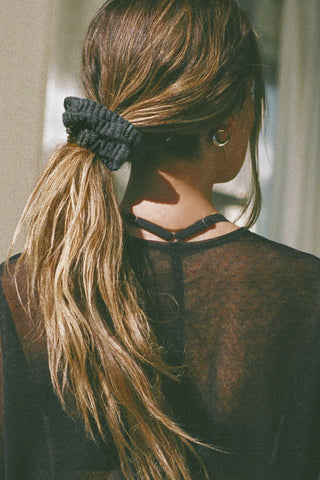 Back view of model wearing the soft and stretchy ink luxe knit Knit Scrunchie wrapped around her pony tail