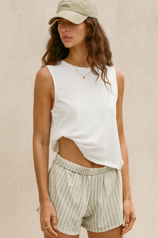 Front view model posing in the relaxed fit optic white cotton Muscle Tank with a crew neckline
