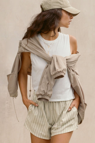 Front view model posing in the relaxed fit optic white cotton Muscle Tank with a crew neckline
