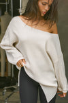 Front view of model posing in the relaxed fit natural luxe knit Off Shoulder Tunic with a wide off-the-shoulder neckline and asymmetrical hem