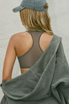 Back view of model posing in the sheer graphite mesh Scoop Neck Racerback Bra with a raceback silhouette