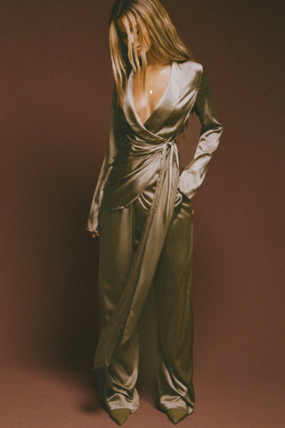 Full body front view of model posing in the smooth and soft sagebrush Silk Wrap Blazer top with an adjustable tie waist and shawl collar neckline.