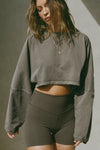 Front view of model posing in the cropped relaxed fit haze cotton Slouchy Crop Long Sleeve top with a crew neckline, dropped shoulders and oversized sleeves