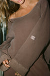 Close up detail front view of model posing in the oversized cedar french terry Slouchy Pullover Sweatshirt with a wide, off-the-shoulder neckline and a JOAH BROWN logo patch on the right sleeve