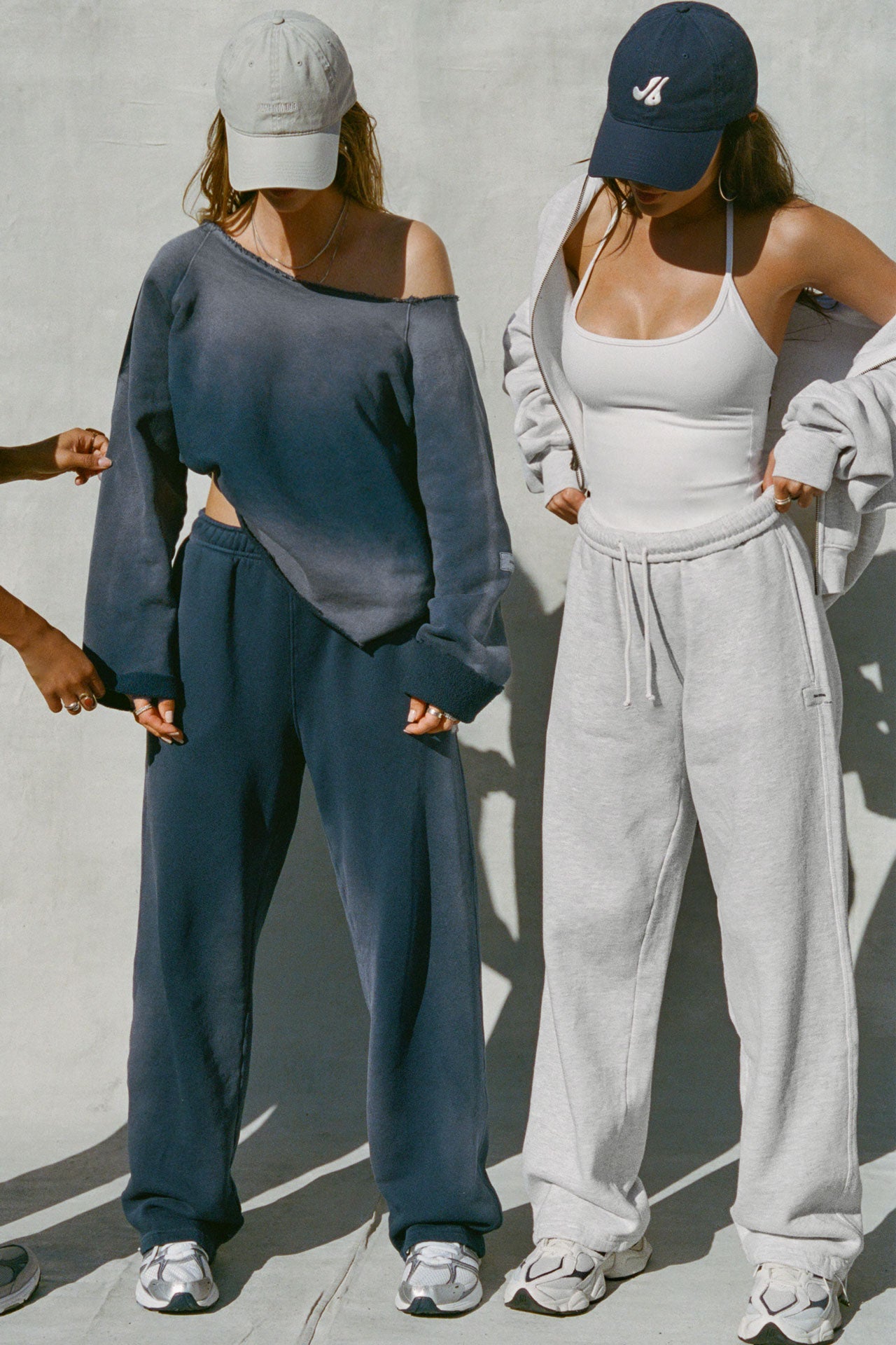 Two modes posing in a heritage washed navy french terry sweat set and a white sueded halter top and pearl french terry bottom set. 