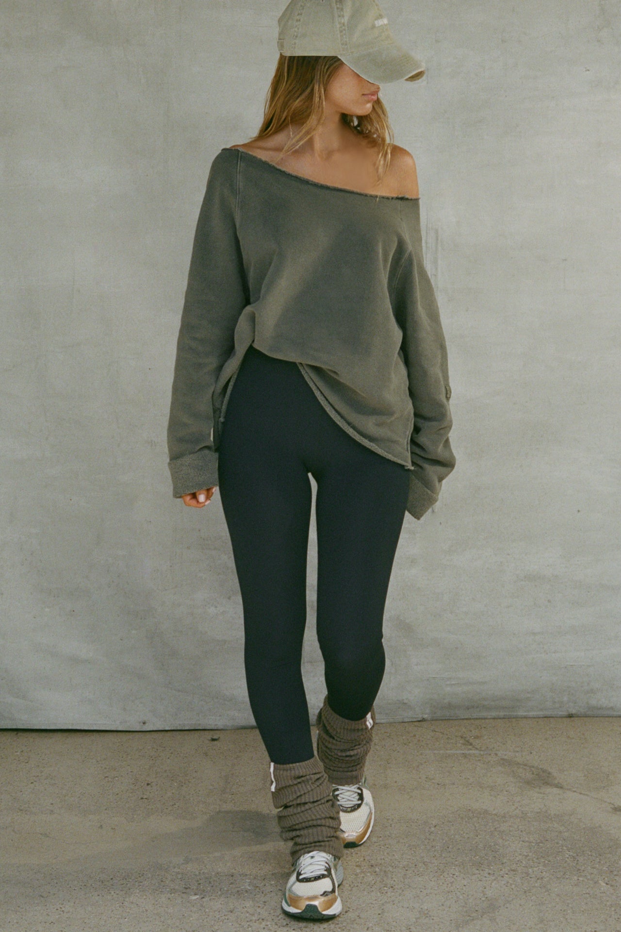 Full body front view of model posing in slouchy, pull on army luxe knit Leg Warmers that can be worn pulled up on scrunched down