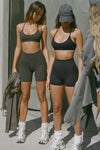 Two models posing in Joah Brown sueded T-Back Bra and Body Short sets