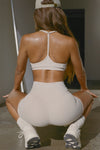 Back view of model posing in the sporty sueded yuma T-Back Bra with a scoop neckline, open T-back and adjustable straps.