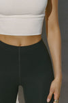 Close up detail front view of model from the waist down posing in the sleek and stretchy full length sueded onyx The Body Legging with a mid-rise elastic waistband