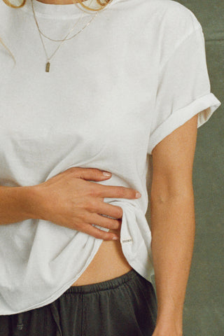 Close up detail front view of model posing in the optic white classic cotton Vintage Tee with a crew neckline and relaxed silhouette