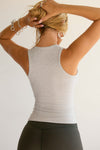 Back view of model posing in the fitted, full length pearl grey flexrib Henley Tank with a notched henley neckline