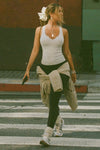 Full body front view of model walking in the street wearing the fitted, full length pearl grey flexrib Henley Tank with a notched henley neckline