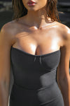 Close up front view of model posing in the fitted strapless sueded onyx Bustier Tube Top with a sweetheart neckline and structured seaming at the bust