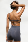 Back view of model posing in the stretchy minimal coverage sueded navy Cage Bra with thin straps and thin horizontal straps in the back