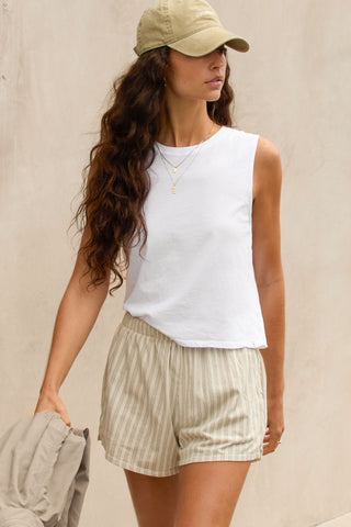 Front view model posing in the relaxed fit optic white cotton Muscle Tank with a crew neckline