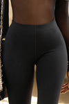 Close up detail front view of model from the waist down posing in the sleek and stretchy full length sueded onyx The Body Legging with a mid-rise elastic waistband