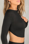 Close up detail side view of model posing in the fitted and cropped black modal Open Boatneck Long Sleeve top with a high neckline,curved hem, open back and adjustable strap details