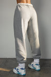 Back view of model from the waist down wearing the oversized loose fit classic grey french terry Oversized Jogger with an elastic waistband and ankle cuffs
