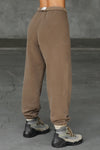 Back view of model from the waist down wearing the oversized loose fit cocoa french terry Oversized Jogger with an elastic waistband and ankle cuffs